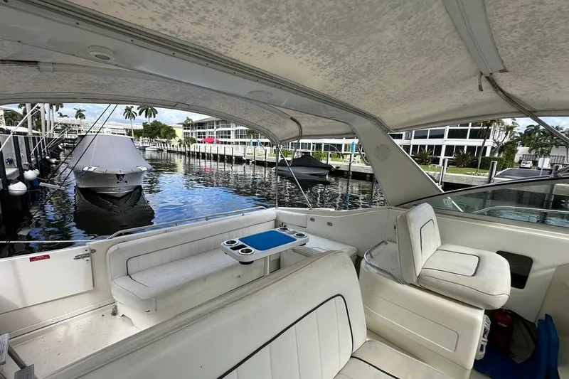 Slide: The Image of 1994 Sea Ray 370 Express Cruiser interior with dockside view, featuring white seating and table. - 30