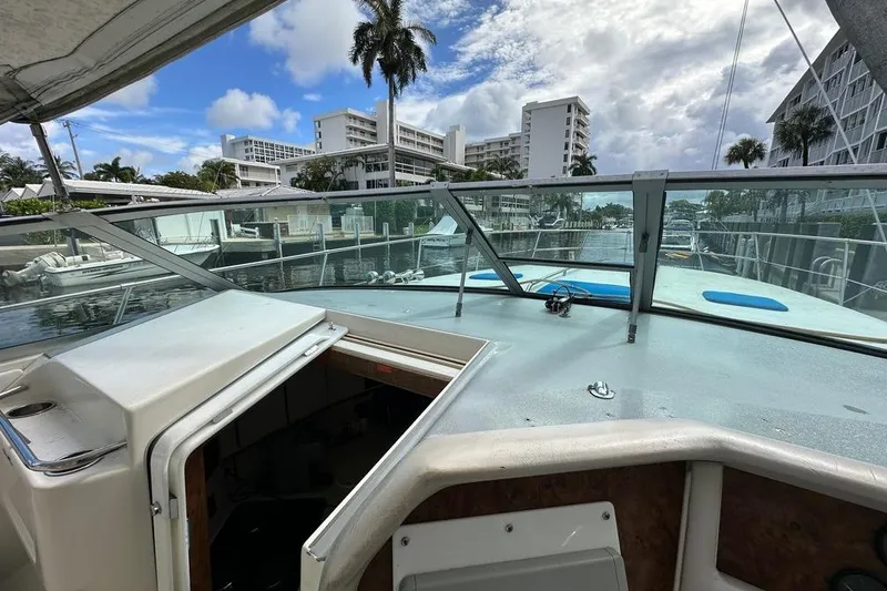 Slide: The Image of 1994 Sea Ray 370 Express Cruiser docked, view from cockpit with cityscape background. - 31