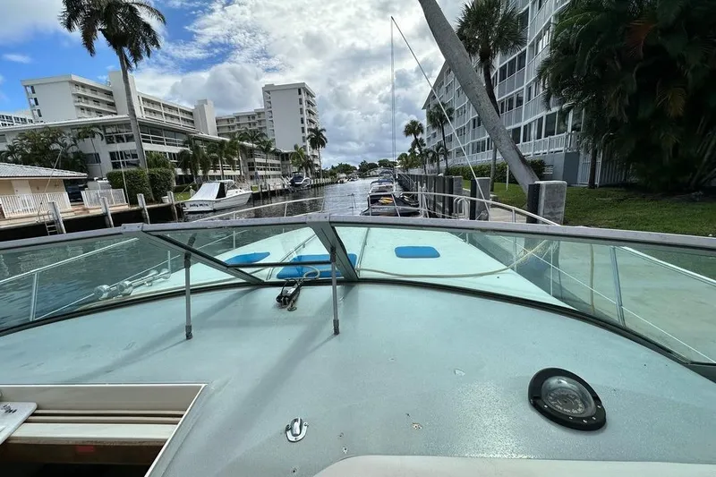 Slide: The Image of 1994 Sea Ray 370 Express Cruiser docked near waterfront buildings and palm trees. - 32