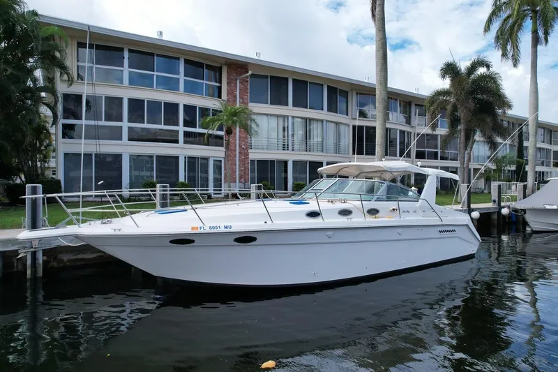 Slide: The Image of 1994 Sea Ray 370 Express Cruiser docked near modern waterfront apartments. - 36