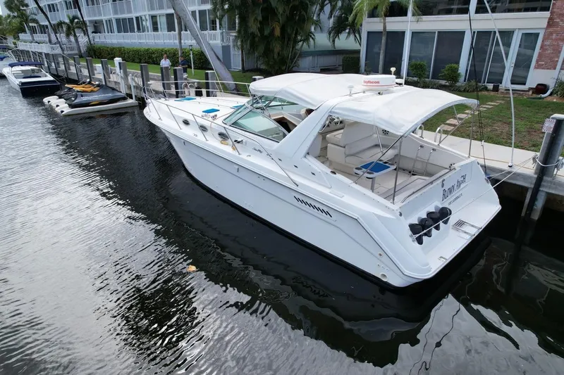 Slide: The Image of 1994 Sea Ray 370 Express Cruiser docked by waterfront buildings. - 39