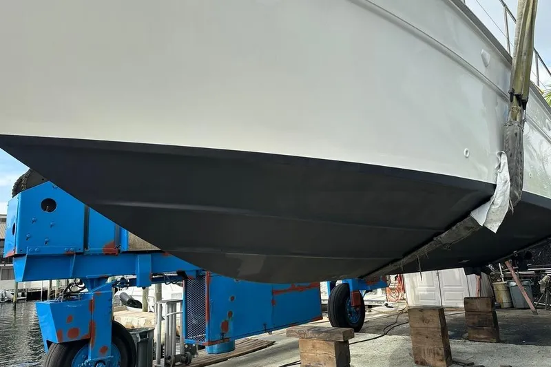 Slide: The Image of 1994 Sea Ray 370 Express Cruiser on dry dock, hull maintenance underway. - 4