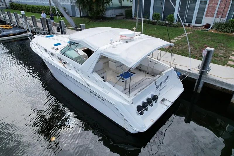 Slide: The Image of 1994 Sea Ray 370 Express Cruiser docked at marina, featuring white canopy and spacious deck. - 40