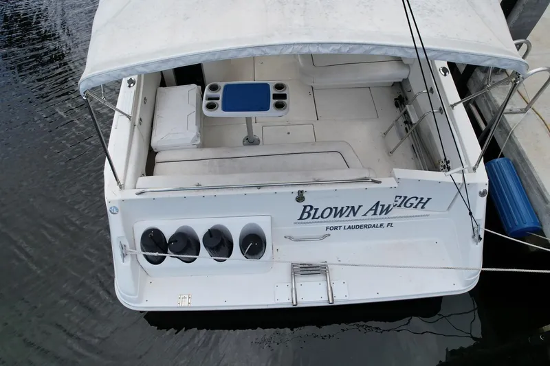 Slide: The Image of 1994 Sea Ray 370 Express Cruiser docked, featuring spacious seating and canopy. - 44