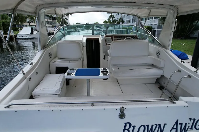 Slide: The Image of 1994 Sea Ray 370 Express Cruiser interior with seating and table, docked by waterfront. - 46