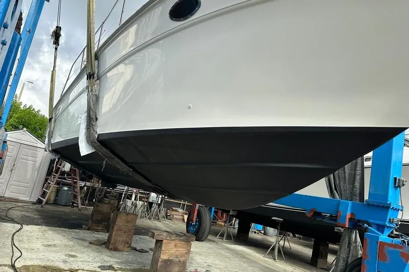 Slide: The Image of 1994 Sea Ray 370 Express Cruiser in dry dock, hull maintenance underway. - 5