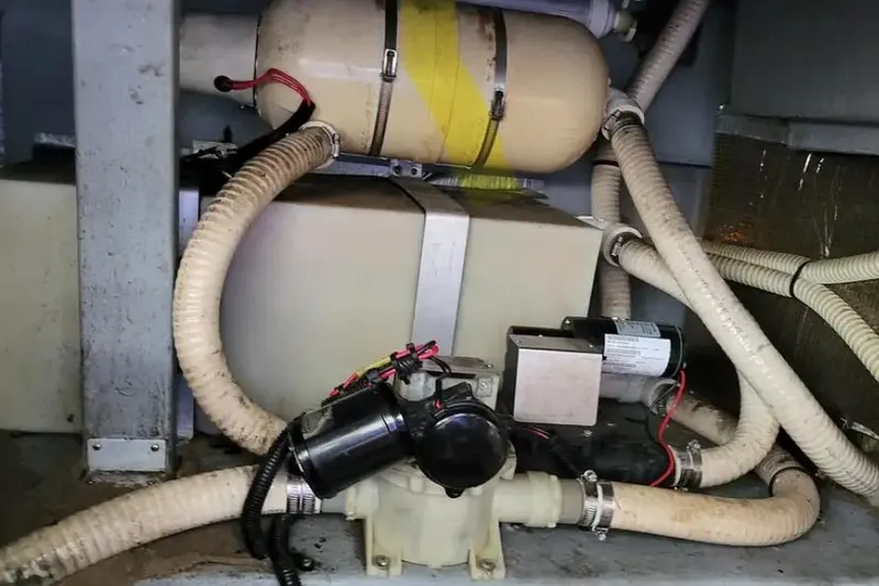 Slide: The Image of 1994 Sea Ray 370 Express Cruiser engine compartment with hoses and mechanical components. - 53