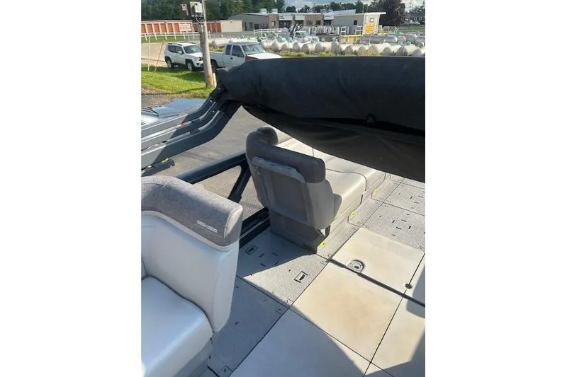 Slide: The Image of 2023 Sea Doo Switch interior with seating and covered canopy, parked outdoors. - 8