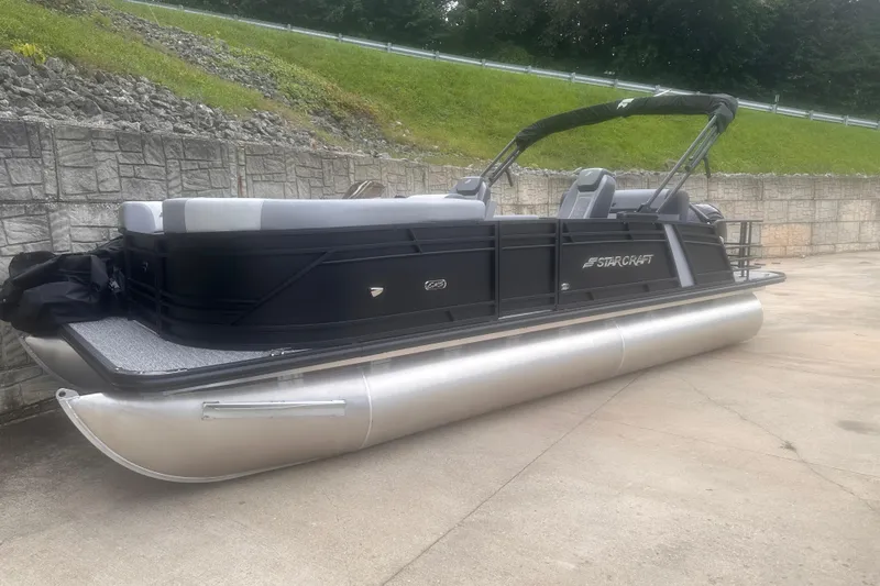 The Image of 2026 Starcraft EXS 3 Q DH pontoon boat with sleek black design on concrete surface. - 0