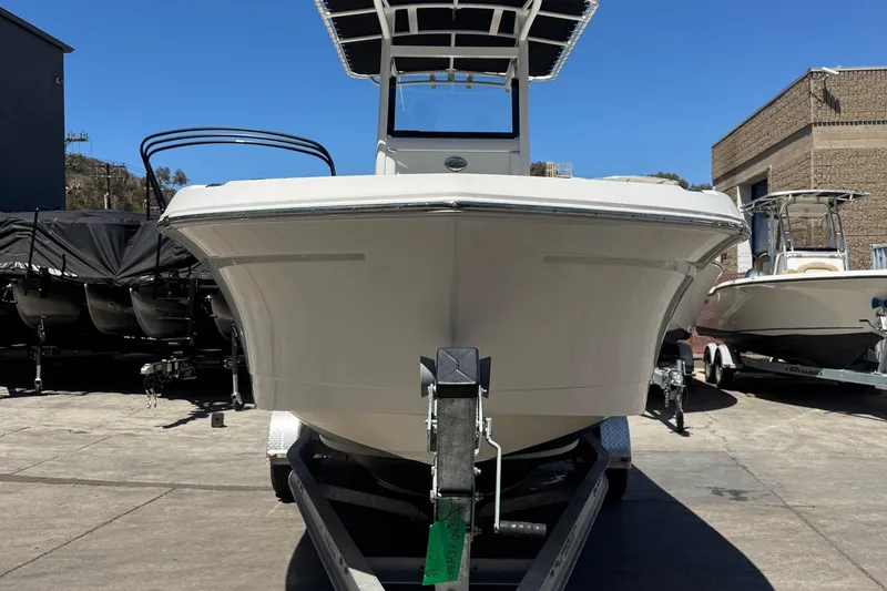 Slide: The Image of 2023 NauticStar 242L Offshore boat on trailer, front view, in a marina setting. - 10