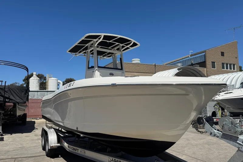 Slide: The Image of 2023 NauticStar 242L Offshore boat on trailer, outdoor setting. - 11