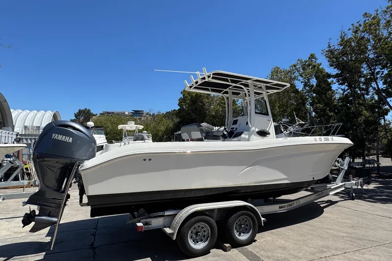 Slide: The Image of 2023 NauticStar 242L Offshore boat on trailer with Yamaha engine, outdoors. - 14