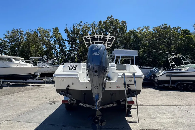 Slide: The Image of 2023 NauticStar 242L Offshore boat with powerful outboard motor, parked in marina. - 15