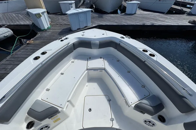 Slide: The Image of 2023 NauticStar 242L Offshore boat interior with seating and storage at dock. - 19
