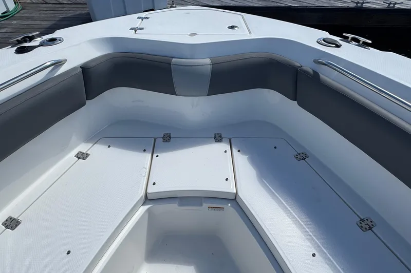 Slide: The Image of 2023 NauticStar 242L Offshore boat interior with cushioned seating and storage compartments. - 21