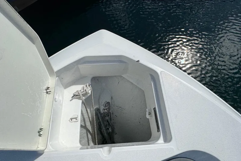 Slide: The Image of Open anchor compartment on 2023 NauticStar 242L Offshore boat, with ropes visible. - 23