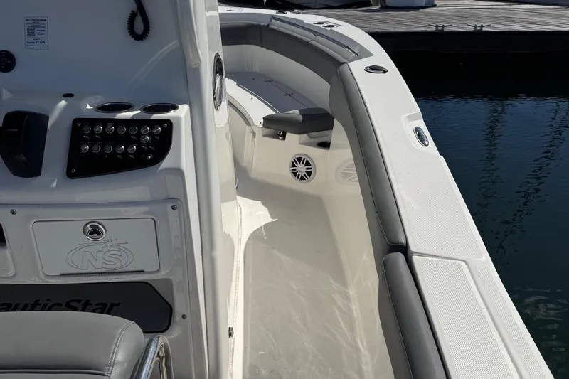 Slide: The Image of 2023 NauticStar 242L Offshore boat interior with seating and control panel. - 36