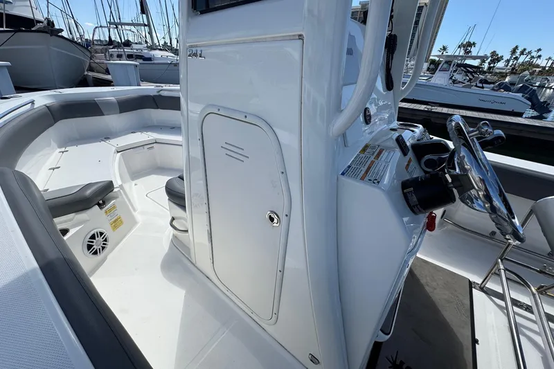 Slide: The Image of 2023 NauticStar 242L Offshore boat interior with steering console and seating area. - 46