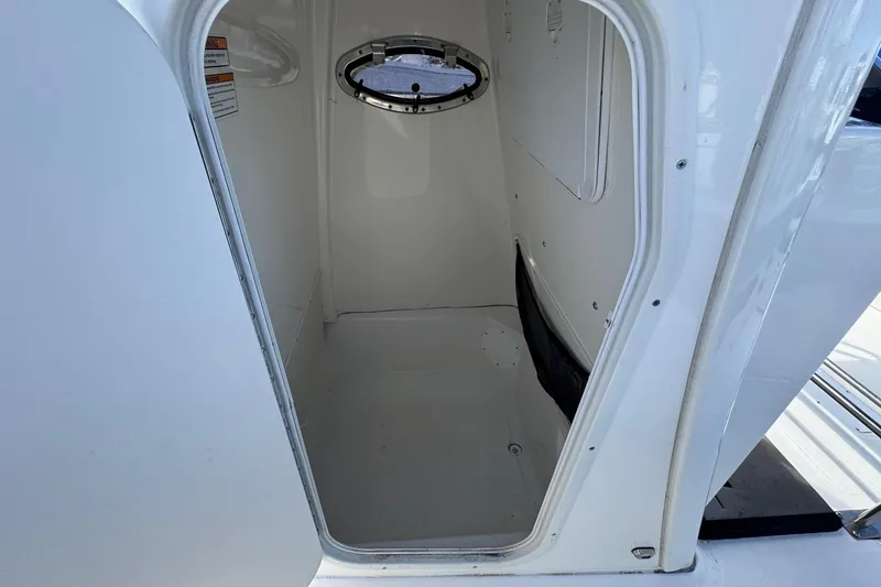 Slide: The Image of 2023 NauticStar 242L Offshore boat interior cabin with porthole window. - 47