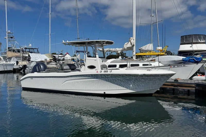 Slide: The Image of 2023 NauticStar 242L Offshore boat docked in a marina under a clear blue sky. - 53