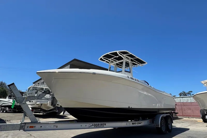 Slide: The Image of 2023 NauticStar 242L Offshore boat on trailer under clear blue sky. - 9
