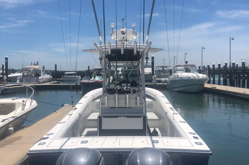 Slide: The Image of 2000 Regulator 26 Center Console boat docked at marina under clear blue sky. - 1