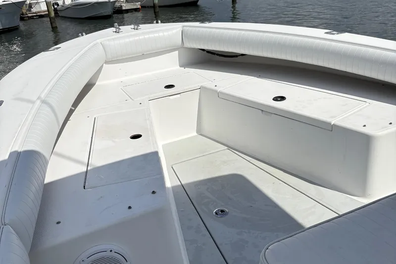 Slide: The Image of 2000 Regulator 26 Center Console boat interior with white seating and storage compartments. - 12