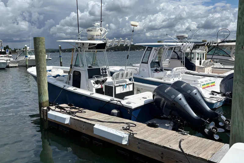 Slide: The Image of 2000 Regulator 26 Center Console boat docked with twin outboard engines. - 2