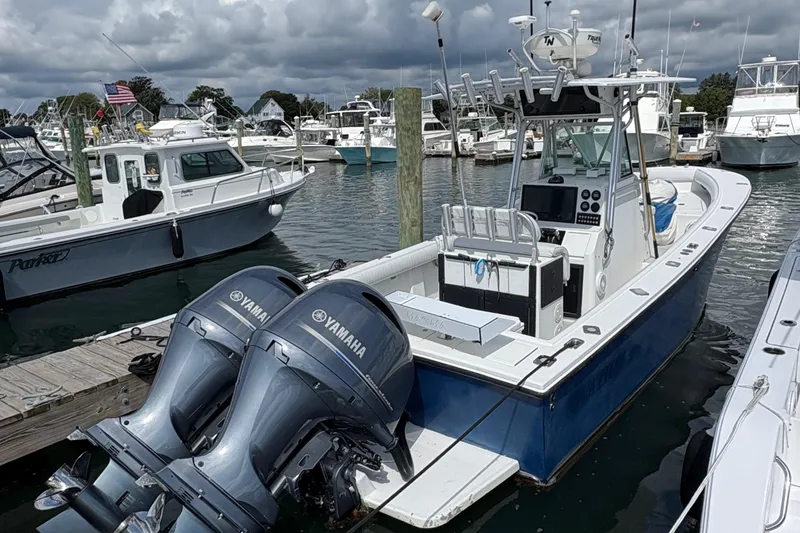 Slide: The Image of 2000 Regulator 26 Center Console boat docked with twin Yamaha engines. - 3