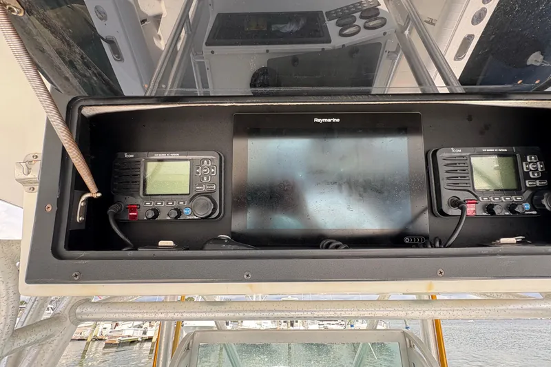 Slide: The Image of 2000 Regulator 26 Center Console dashboard with Raymarine display and Icom radios. - 4