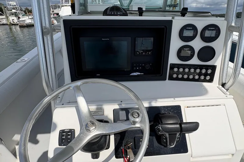 Slide: The Image of 2000 Regulator 26 Center Console boat dashboard with steering wheel and control panel. - 5
