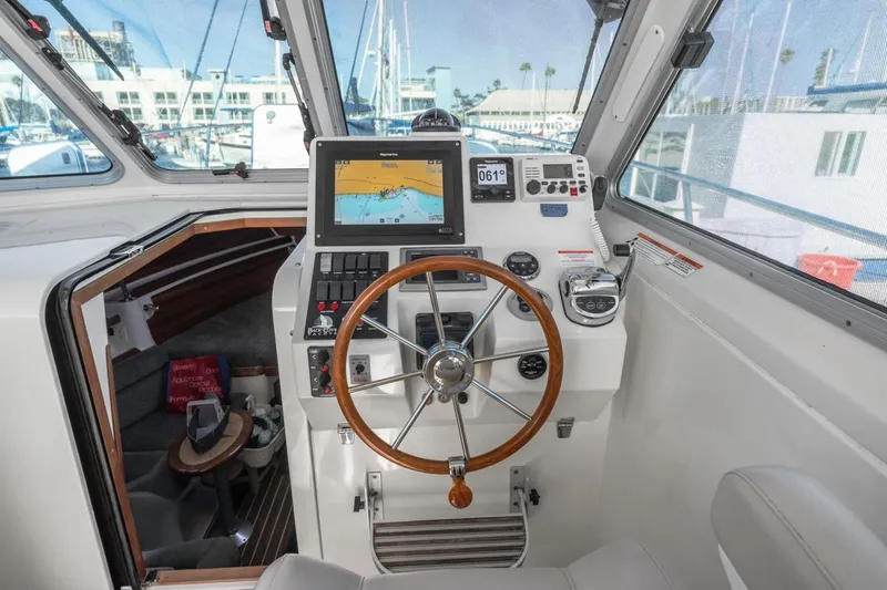 Slide: The Image of 2008 Back Cove 33 boat helm with navigation equipment and wooden steering wheel. - 12