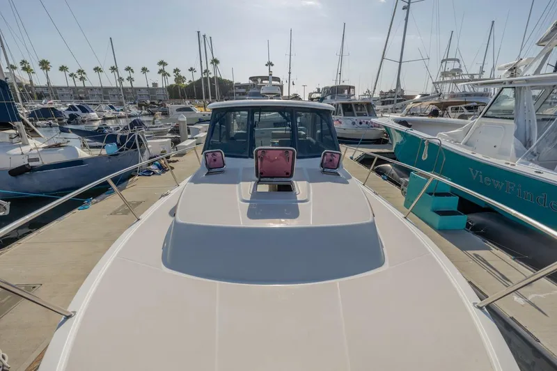Slide: The Image of 2008 Back Cove 33 boat docked at a marina, surrounded by other vessels. - 16