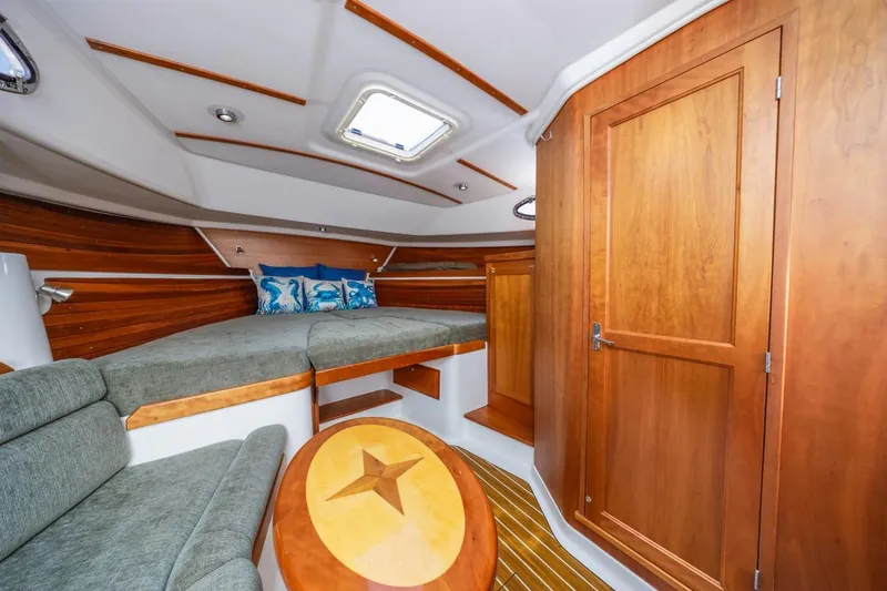 Slide: The Image of 2008 Back Cove 33 yacht interior with wood finish, cozy seating, and nautical decor. - 19