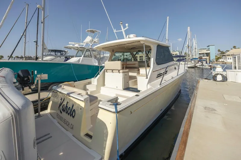 Slide: The Image of 2008 Back Cove 33 boat docked at marina, featuring spacious deck and sleek design. - 5