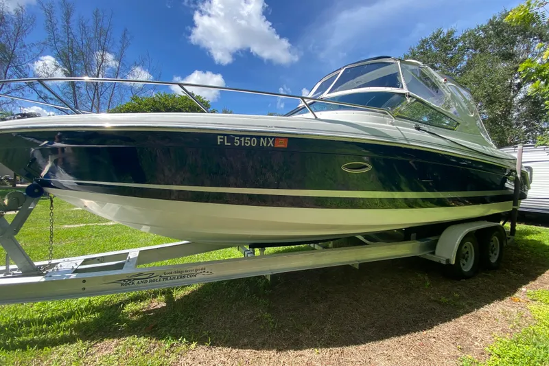 The Image of 2005 Formula 280 Sun Sport boat on trailer, parked outdoors under a clear blue sky. - 0