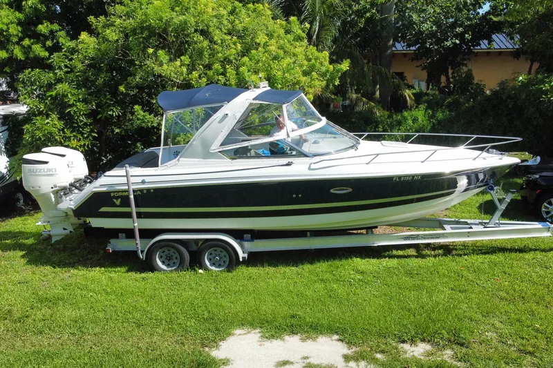 Slide: The Image of 2005 Formula 280 Sun Sport boat on trailer, parked on grass with lush greenery background. - 15