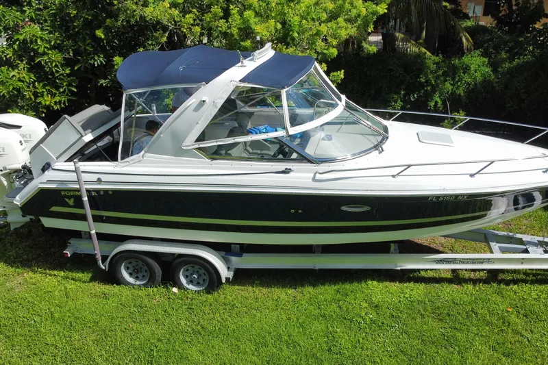 Slide: The Image of 2005 Formula 280 Sun Sport boat on trailer, surrounded by lush greenery. - 21