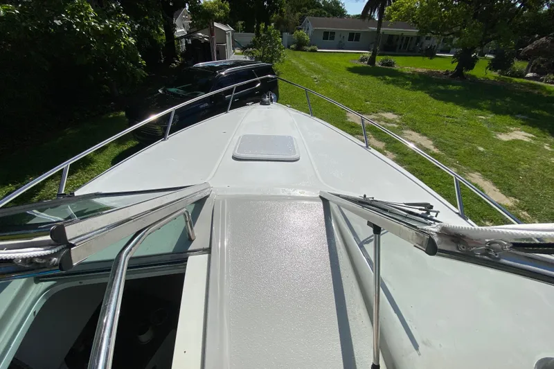 Slide: The Image of 2005 Formula 280 Sun Sport boat deck with open hatch, parked in a grassy yard. - 26