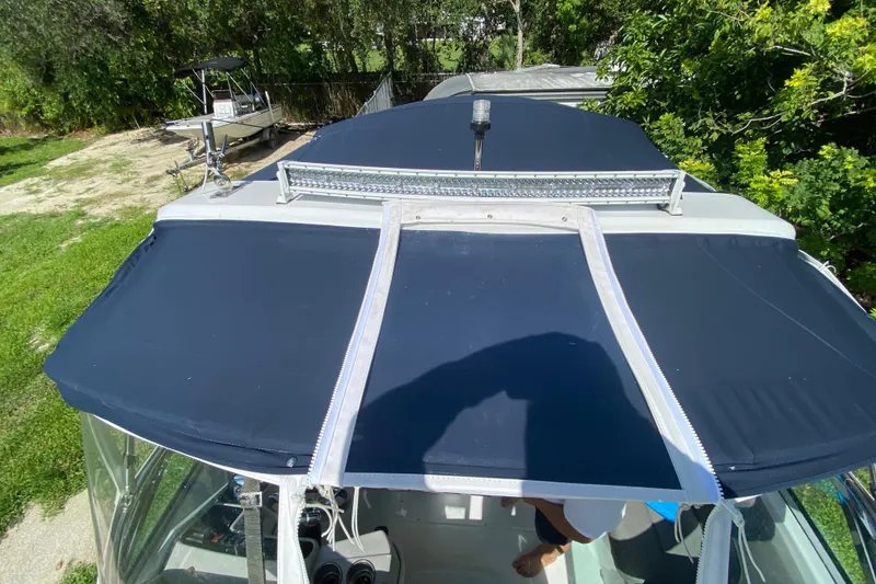 Slide: The Image of 2005 Formula 280 Sun Sport boat with blue canopy, parked outdoors. - 53