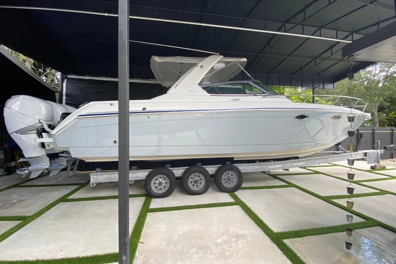 The Image of 2005 Formula 330 Sun Sport boat on trailer under a covered area. - 1
