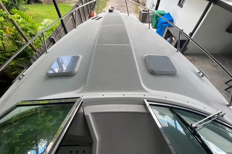 Slide: The Image of 2005 Formula 330 Sun Sport boat deck with open hatches, surrounded by greenery. - 14