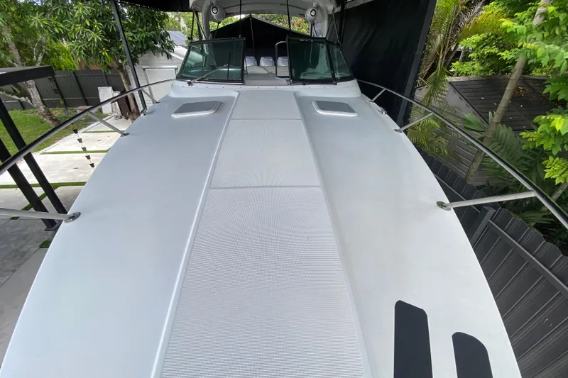 Slide: The Image of 2005 Formula 330 Sun Sport boat deck, sleek design, surrounded by lush greenery. - 15