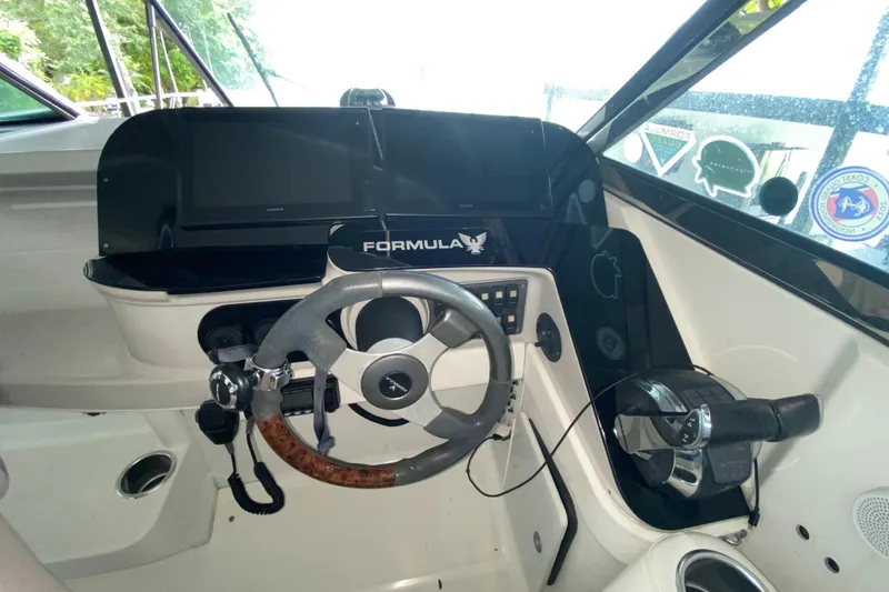 Slide: The Image of 2005 Formula 330 Sun Sport boat cockpit with steering wheel and control panel. - 25