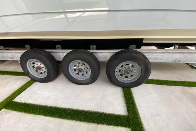 Slide: The Image of Trailer wheels of a 2005 Formula 330 Sun Sport boat on concrete with grass strips. - 36