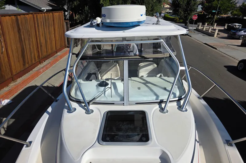 Slide: The Image of 2003 Boston Whaler 255 Conquest boat, top view, parked on a residential street. - 15
