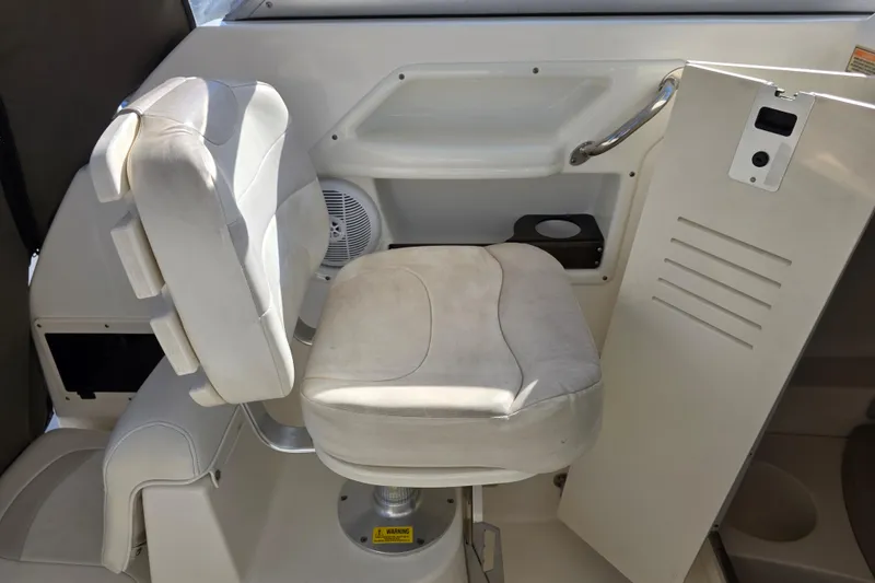 Slide: The Image of 2003 Boston Whaler 255 Conquest interior with white captain's chair and control panel. - 18