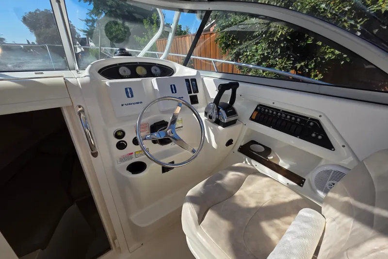 Slide: The Image of 2003 Boston Whaler 255 Conquest helm with steering wheel and control panel. - 20