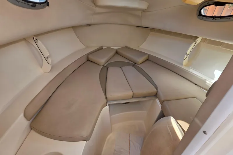 Slide: The Image of 2003 Boston Whaler 255 Conquest cabin interior with cushioned seating and portholes. - 29