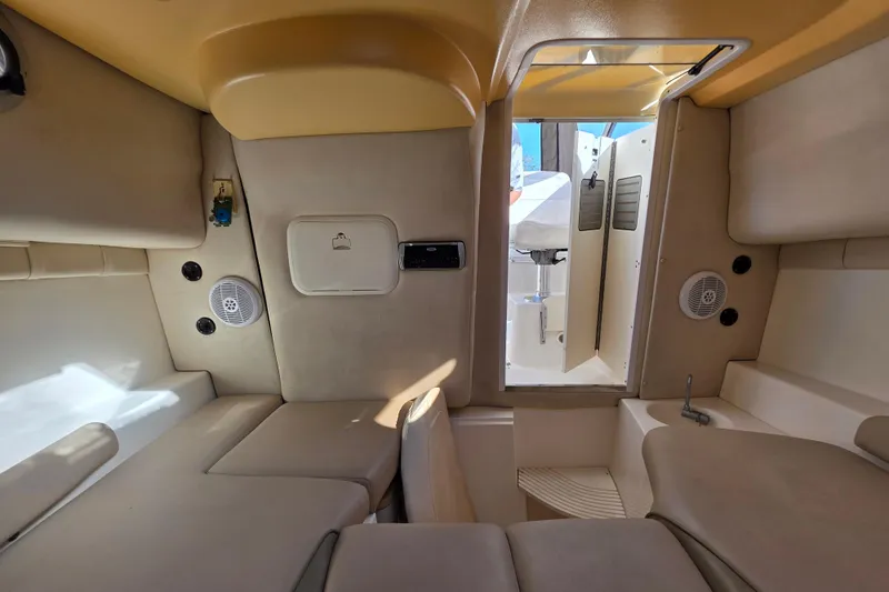 Slide: The Image of Interior cabin of 2003 Boston Whaler 255 Conquest boat, featuring beige seating and storage. - 30